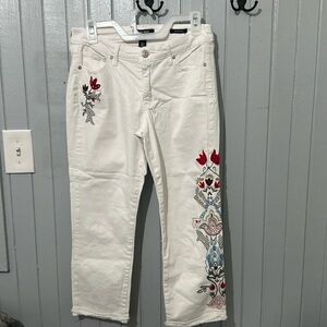 White denim capris with floral embroidery.
